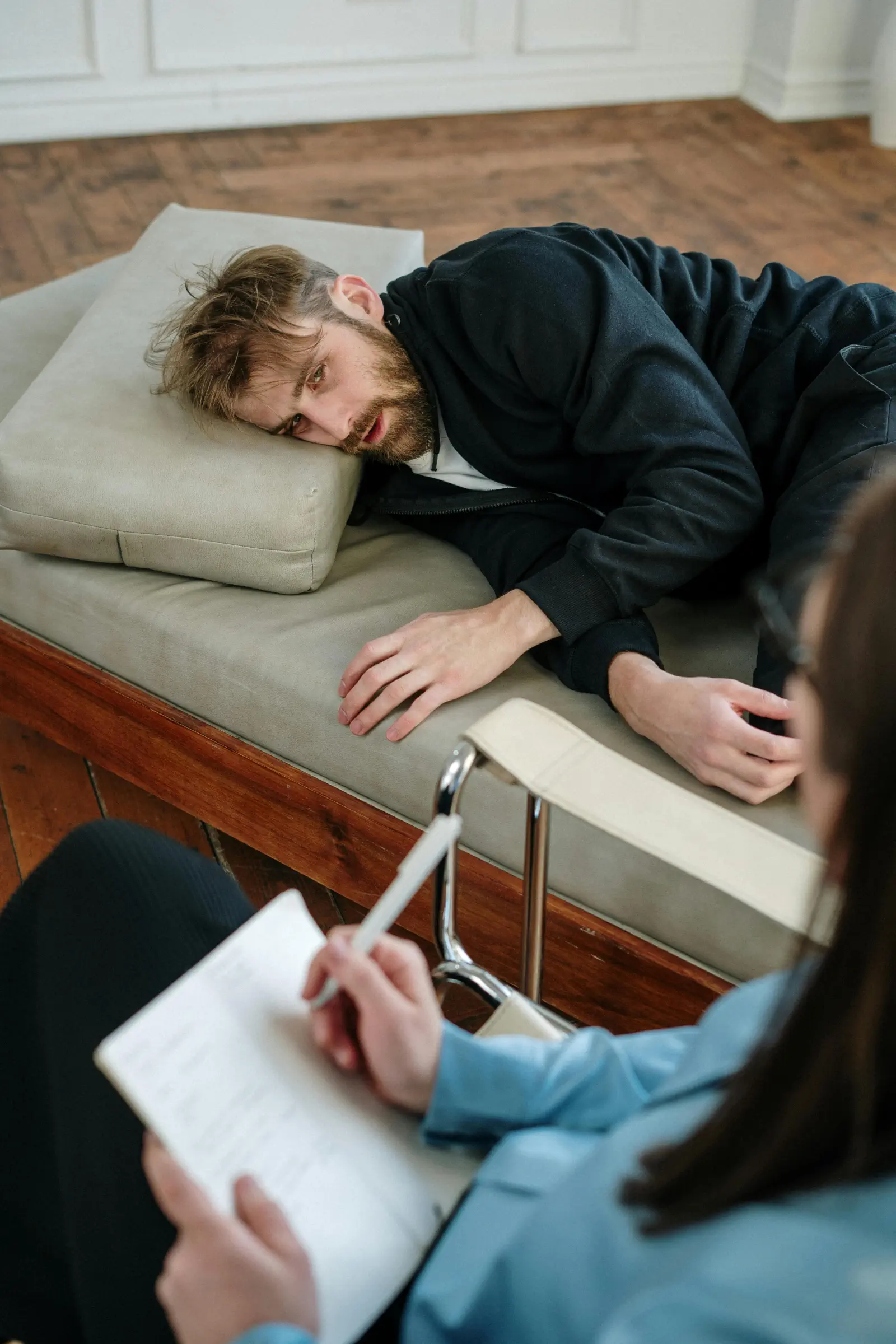 En man ligger på en soffa hos en psykolog och pratar